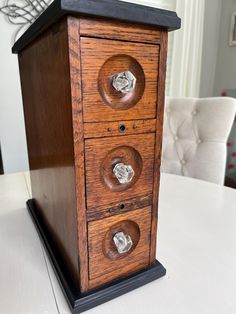 a wooden cabinet sitting on top of a white table