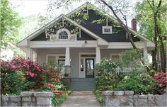 a house with flowers and bushes around it