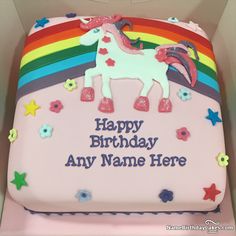 a pink birthday cake with a unicorn on the top and rainbow decorations around the edges