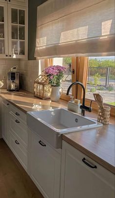 a white kitchen sink sitting under a window