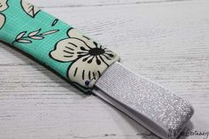 a green and white flowered fabric key fob with silver sequins on it