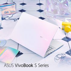 an asus vivobook s series laptop sits on the floor next to other items