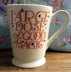 a coffee cup with the words large dose of good magic on it sitting on a table