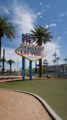 the welcome to las vegas sign in front of palm trees