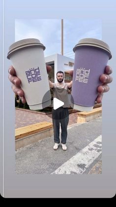 a man holding two coffee cups in his hands