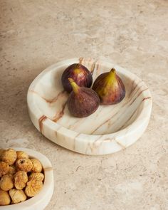 two figs and some nuts on a marble plate