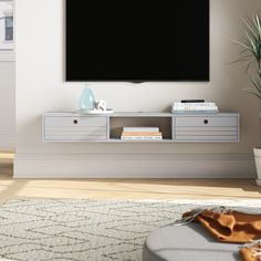 a flat screen tv mounted to the side of a white wall in a living room