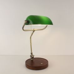 a green desk lamp with a wooden base