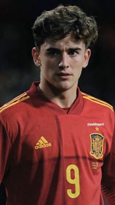 a young man wearing a red and yellow soccer uniform with the number 9 on it