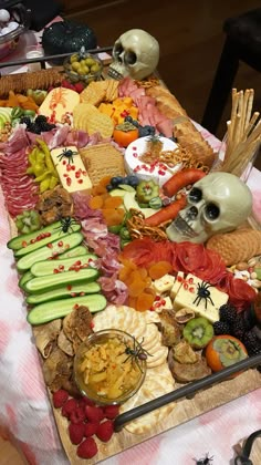 a table topped with lots of different types of food and skulls on top of it