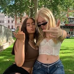 two women are posing for the camera with their hands in the air and one is pointing