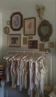 there are many pictures on the wall and clothes hanging up in front of each other