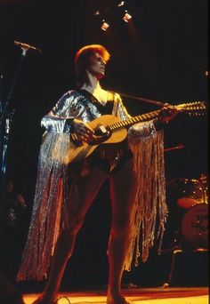 a woman with an electric guitar on stage