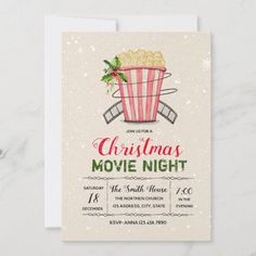 a christmas movie night party with popcorn in a bucket and holly wreath on the top