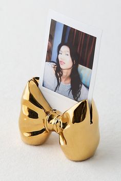 a gold bow shaped photo holder with a photograph in it