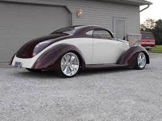 an antique car parked in front of a garage