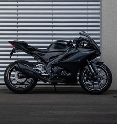 a black motorcycle parked in front of a garage door