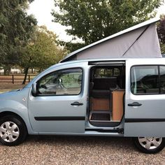 a small van with its door open and the inside doors opened to show it's interior