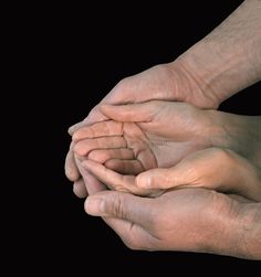 two hands holding each other on black background royalty images and clippings are included in this image