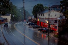 cars are parked on the side of the road in the rain