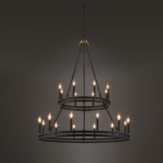 a chandelier with many lit candles hanging from it's centerpiece in a dark room