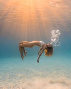 a woman is diving in the water with her head above the water's surface