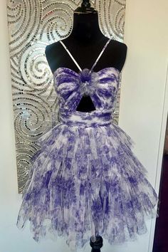 Step into the spotlight with the Hera Straps Purple Floral Print Keyhole Ruffle Homecoming Dress. This A-line dressis crafted from delicate tulle fabric, showcases a vibrant purple floral print that radiates femininity. The halter neckline with a keyhole detail adds a touch of allure, while the ruffled accents cascade beautifully, adding movement and flair to every step. The lace-up back ensures a customizable fit that highlights your figure. This dress promises to be the showstopper of the nigh