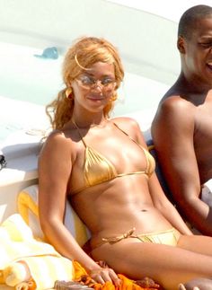 a man and woman in bikinis sitting on a boat