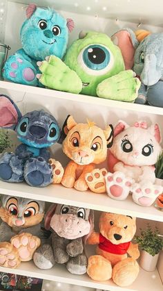 several stuffed animals are sitting on shelves in a toy store, one is blue and the other is orange