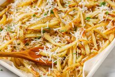 french fries with parmesan cheese in a casserole dish on a marble surface