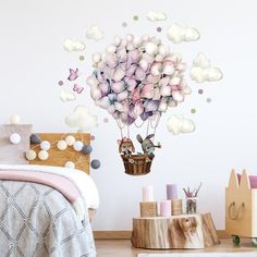 a bedroom with a bed, nightstand and wall decal that has flowers in the air