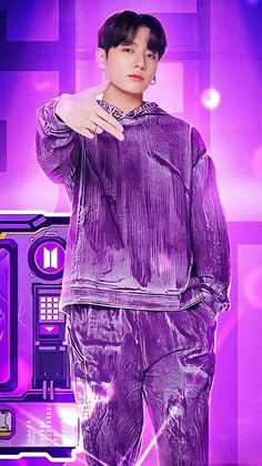 a male in a purple outfit is posing for the camera with his hand on his hip