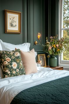 a bedroom with green walls and white bedding, two framed pictures on the wall