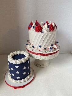 two patriotic cakes sitting next to each other on top of a white table with red, white and blue decorations