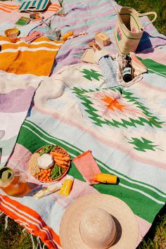 a picnic blanket with food and drinks on it