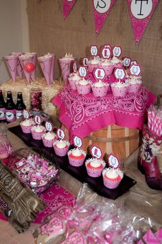 a table topped with lots of cupcakes and candy