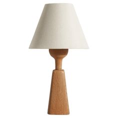 a wooden table lamp with a white shade on the top and bottom part of it