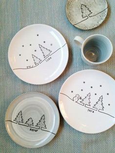 three plates and two cups with designs on them