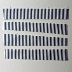 four strips of black and white striped paper with holes in the middle, all lined up