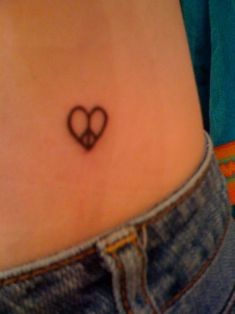 a small heart tattoo on the stomach