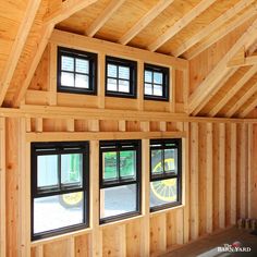 the inside of a wooden building with three windows