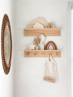 two wooden shelves with decorative objects on them and a mirror above one that is hanging from the wall