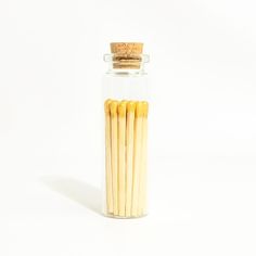 several matches in a glass jar on a white background