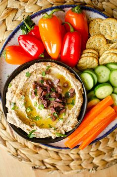 hummus, carrots, cucumbers and crackers on a plate