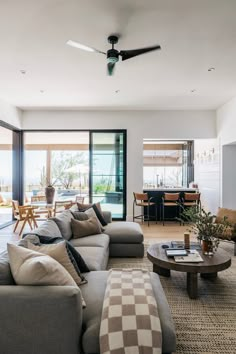 a living room filled with furniture and a ceiling fan