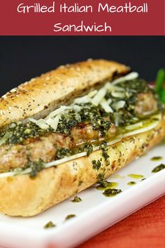 grilled italian meatball sandwich with pesto and parmesan cheese on a white plate