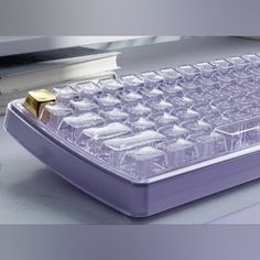 a purple computer keyboard sitting on top of a desk