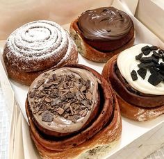 three pastries in a box with chocolate frosting and oreo cookies on top