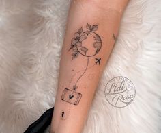 a woman's arm with a tattoo on it that has flowers and an airplane flying through the sky