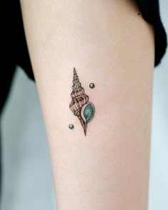 a small seashell tattoo on the right side of the leg, with an ocean theme